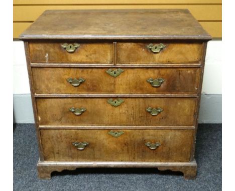 A Georgian oak and walnut veneer chest of three long and two short drawers, on bracket feet and with brass furniture, circa 1