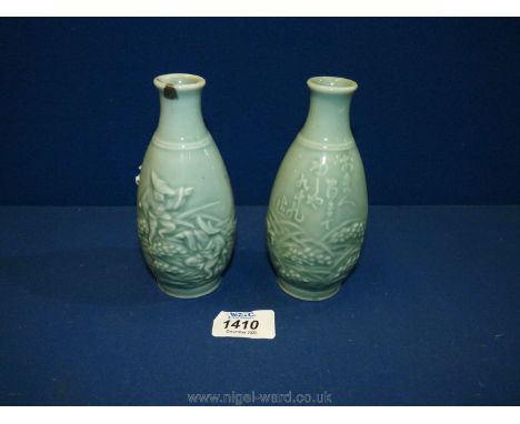 A pair of jade green coloured oriental Vases depicting two men in a field, one having slight damage to the rim, 5 3/4" tall a