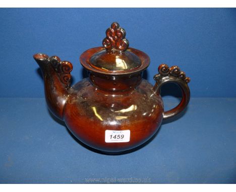 A large brown glazed teapot with spiral decoration to the spout, handle and finial, marked KK to base.