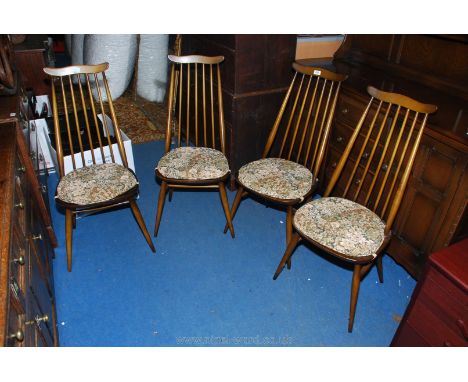 A set of four "Ercol" dark-wood stick back Dining Chairs having "H" stretchers and solid wood seats.