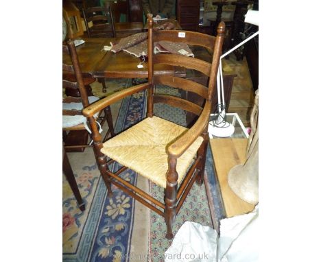 A good Oak ladder back open armed Elbow Chair having turned legs, stretchers and back supports terminating in appropriate aco