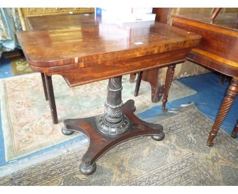 An early 19th c. Regency cross-banded Mahogany and Walnut flap-over Tea Table having a turned tapering pillar and platform ba