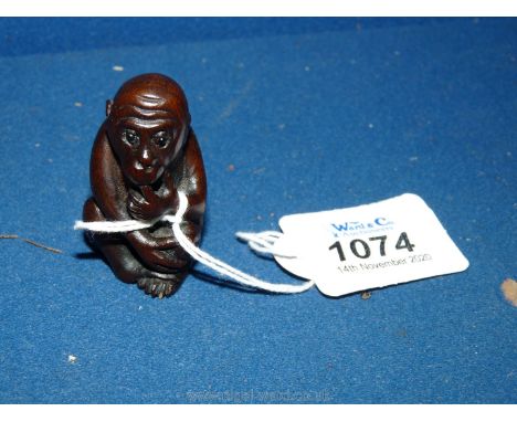 A well carved hardwood Netsuke in the form of a Monkey seated with pensive expression, 2 1/2'' tall.