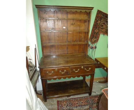 An appealing compact Oak pot board Welsh Dresser having fret-worked frieze and apron, a pair of frieze drawers with brass dro