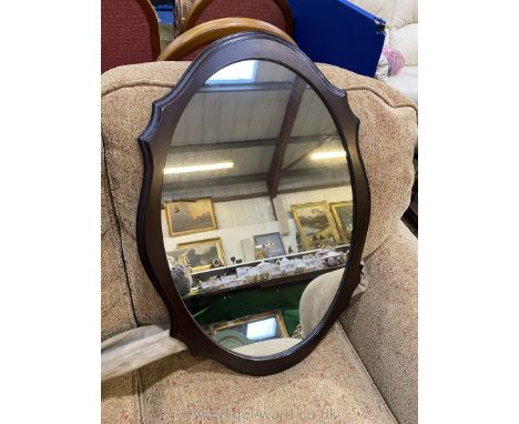 A shaped edge darkwood finished framed oval Wall hanging Mirror, 27" x 19" overall.