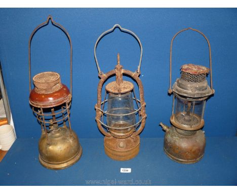 Two Tilley lamps a/f. and a hurricane lamp.