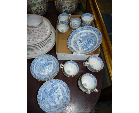 An oriental blue and white service having scalloped rimmed edging to include thirteen cups, eight saucers and a bread and but