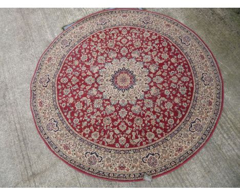 A circular Kasbah rug, red border, with cream floral pattern surround and central panel in flowers and leaves, 79'' diameter.