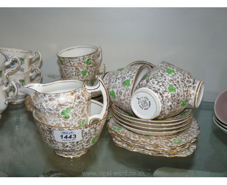 A green clover and gold twenty-one piece Phoenix bone china part Teaset including six cups, saucers and tea plates, cake plat