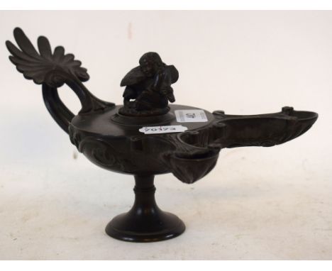 A bronze neoclassical oil lamp, with twin nozzles, the cover in the form of a winged child holding a bird, the body with an a
