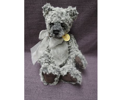 A Charlie Bears Jointed Teddy bear named Torquil having plastic eyes, stitched nose and mouth, two tone grey plush body and h