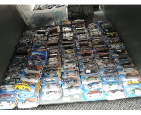 A shelf of modern Mattel Hotwheels diecasts, all on bubble cards, approx 100, some opened