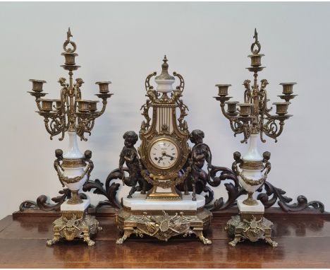 A Paris Regnant Empire style clock with white marble and brass cherub fauns holding floral swag and two candlestick garniture