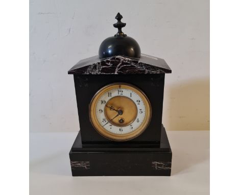 A black slate mantle clock with finial to top