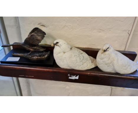 A modern bronzed metal sculpture of a swan taking to flight and a pair of ceramic white doves