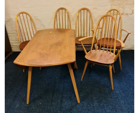 An Ercol elm sideboard drop leaf table and a set of six stick back dining chairs one chair with damage.