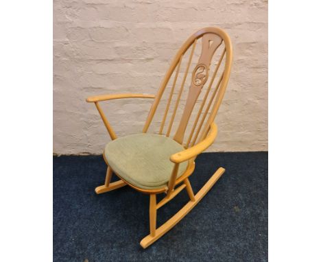 An Ercol rocking chair with green pad.