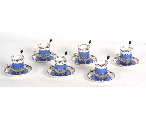 Six Art Deco George Jones porcelain coffee cans and saucers, the cans with hallmarked silver pierced frames and scroll handle