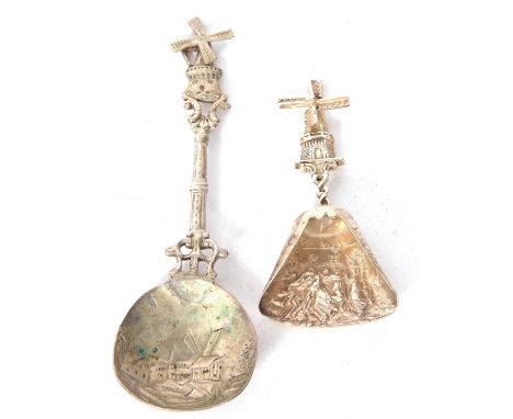 A Dutch white metal caddy spoon, the shovel shaped bowl embossed with a tavern scene having a windmill finial, together with 