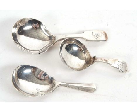 A group of three silver caddy spoons, a small George III example, fiddle pattern having a circular bowl and engraved initials