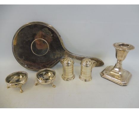 A silver backed dressing table mirror, a small silver candlestick and four silver candlesticks. 