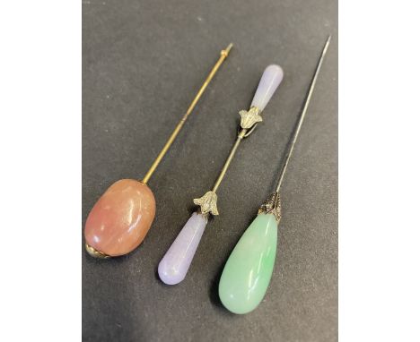 Two good quality hardstone mounted hat pins, one with jade end, plus a double ended pin, with mauve hardstone ends.