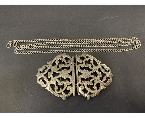A silver two piece nurse's belt buckle of scrolled pierced form plus a sterling silver chain. Combined weight approximately 5