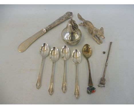 A silver pear shaped container, a silver butter knife, four silver spoons, a twizzle stick etc. 