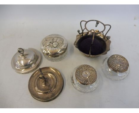 A selection of silver including a ring tree, three silver lidded glass dressing table pots and a pin cushion.