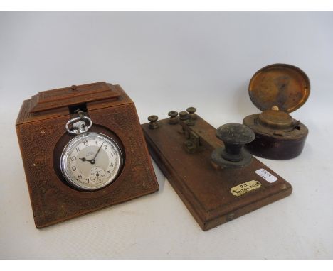 A heavily carved watch stand, a travel inkwell and a morse code machine. 