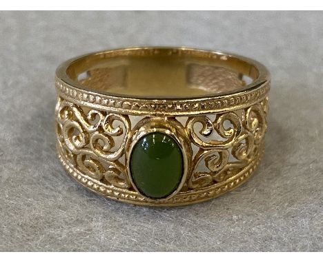 A 9ct gold filigree work ring set with an oval central green stone (possibly jade). Approximately 4g.