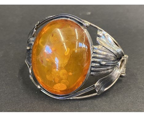 An Art Nouveau silver bracelet inset with a very large oval piece of amber, marked .925.