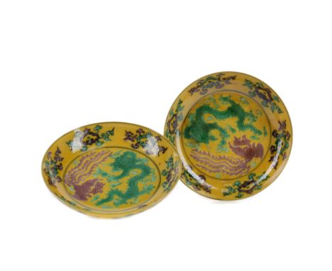 PAIR OF 20TH CENTURY CHINESE DISHES, of circular form, each painted with a dragon and pheonix on a yellow ground, painted sea