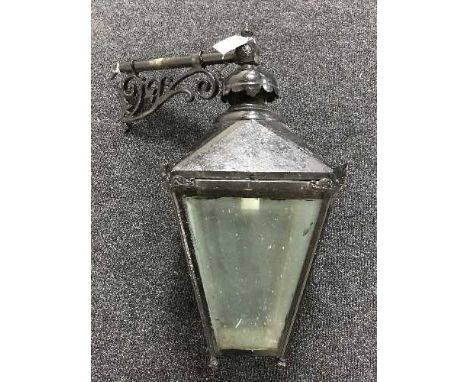 A vintage metal wall lantern with brackets
