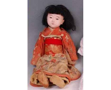 An early 20th century European composition doll of a Japanese baby, having fixed brown eyes, painted features, jointed limbs,