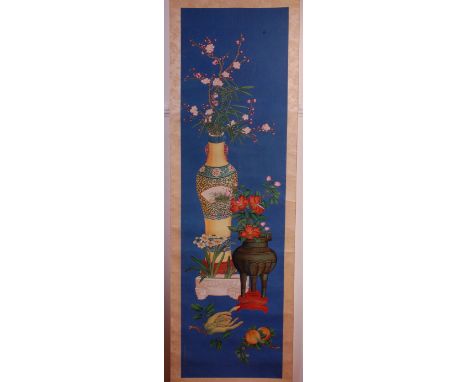 A circa 1900 Chinese silkwork scroll painting, depicting fruit and vases issuing blossoming flowers against a blue background