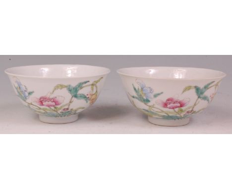 A pair of Chinese porcelain footed bowls, each enamel decorated with blossoming flowers on a white ground, six character Kuan