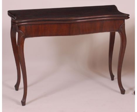 A late 18th century mahogany card table, of serpentine outline, the fold-over top (distressed and showing significant traces 
