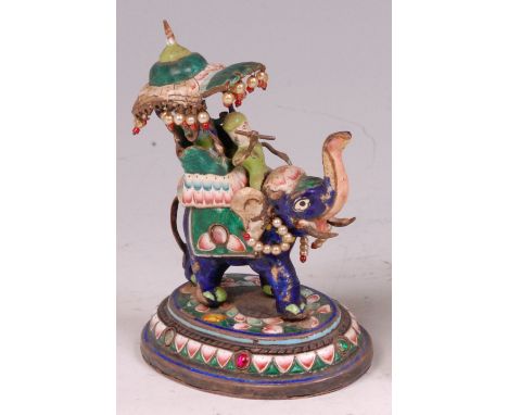 An early 20th century Indian enamel on metal figure of an elephant with howdah, having raised trunk and jewelled decoration o