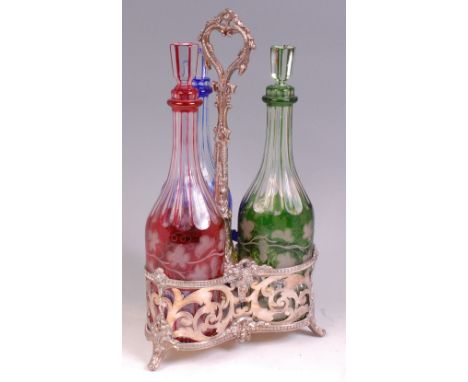 A late 19th century silver plated three-bottle decanter stand, of pierced trefoil shape with centre carry handle, the Bohemia