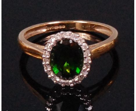 A ladies 9ct gold green tourmaline and diamond set dress ring, the oval cut tourmaline weighing approx. 1.25ct in a surround 