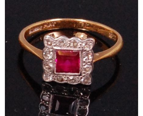 A ladies Art Deco 18ct gold and platinum, ruby and diamond cluster ring, the square cut ruby weighing approx. 0.3ct in a surr