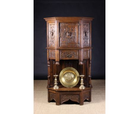 A 19th Century French Renaissance Style Oak Dressoir. The canted cupboard carved in relief with protuberant heads encircled b