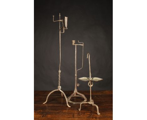 Three Wrought Iron Candle/Rush Lamps: An 18th century floor standing candle light with height adjustable socket on a central 