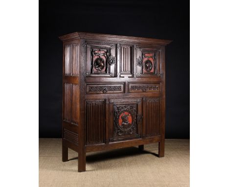 A 16th Century Carved & Painted Aumbry or Press Cupboard. The two upper cupboard doors carved in relief with profiled portrai