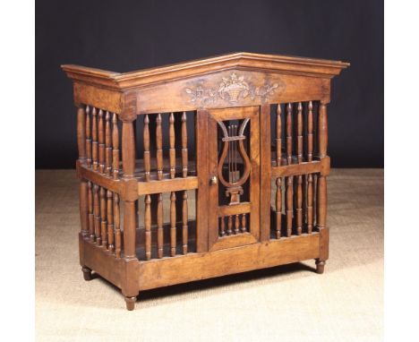 A 19th Century French Walnut Panetière or Food Cupboard. The  apexed pediment carved with a basket of trailing flowers above 