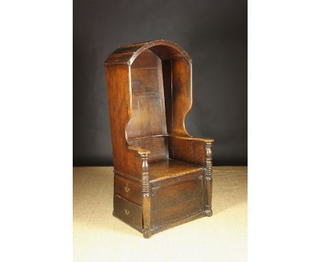 An Impressive 18th Century Oak 'Hall Porter's' Chair.  The planked back having a domed hood with winged sides leading down to