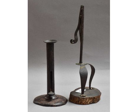 An Iron Rushlight, 18th century, of scissor form with scrolled terminal and twin cabriole legs, on wooden plinth32cm highA To