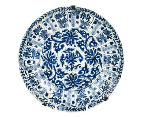 A Chinese Porcelain Dish, Kangxi, painted in underglaze blue with stylised foliage within a broad border of foliage in lappet