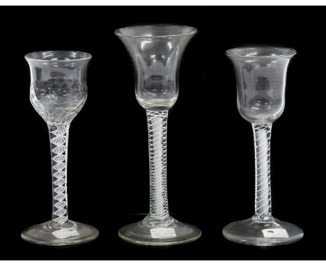 A Wine Glass, circa 1750, the hammered bell shape bowl on an opaque twist stem15cm highTwo Similar Wine Glasses, with plain b